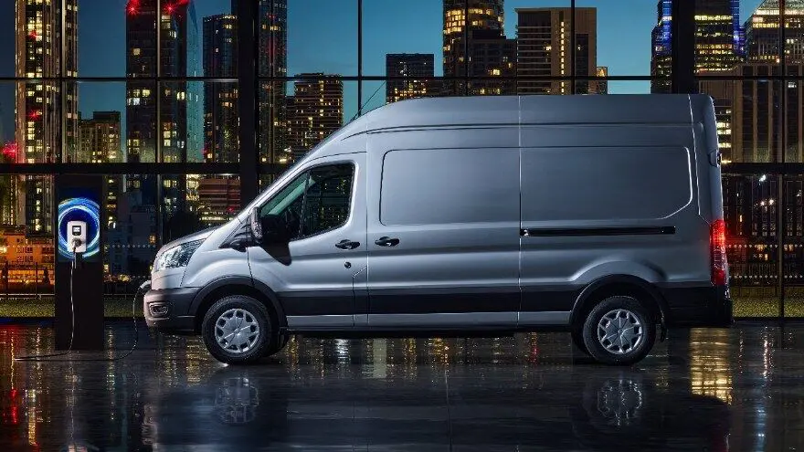 Ford E-Transit parked beside a charging station.