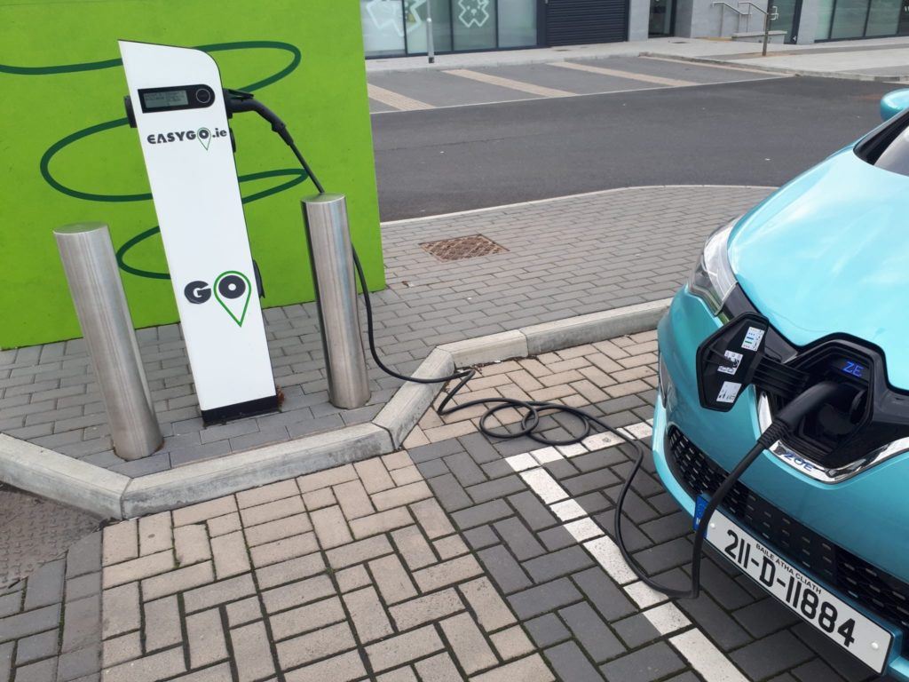 A photograph of the blue Renault ZOE plugged into an EasyGo charger in a carpark