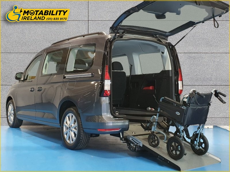 One of Motability's Wheelchair accessible vehicles, a Volkswagen Caddy Maxi Life, with the wheelchair ramp open and an unoccupied wheelchair on it.