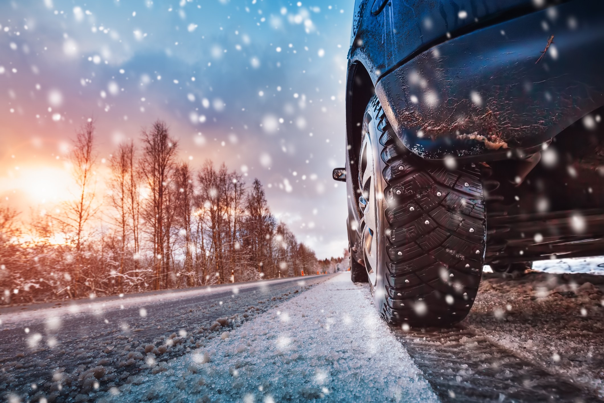 Car tires on winter road covered with snow