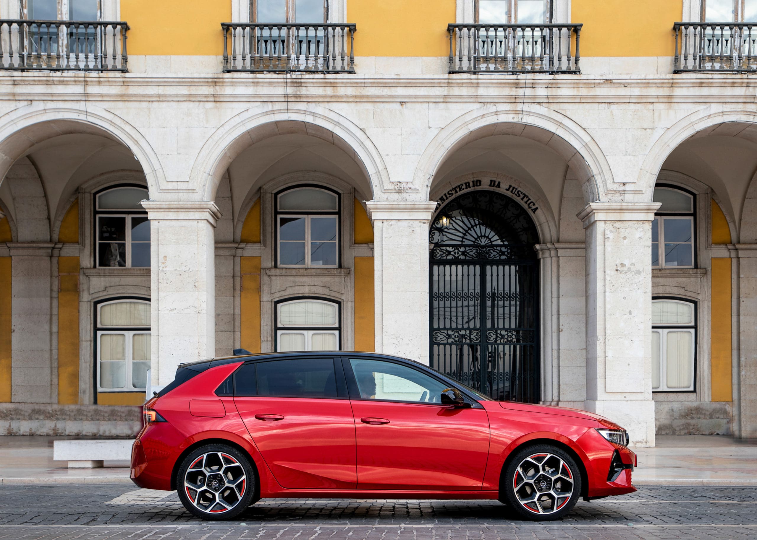 A side profile photo of a red Opel Astra