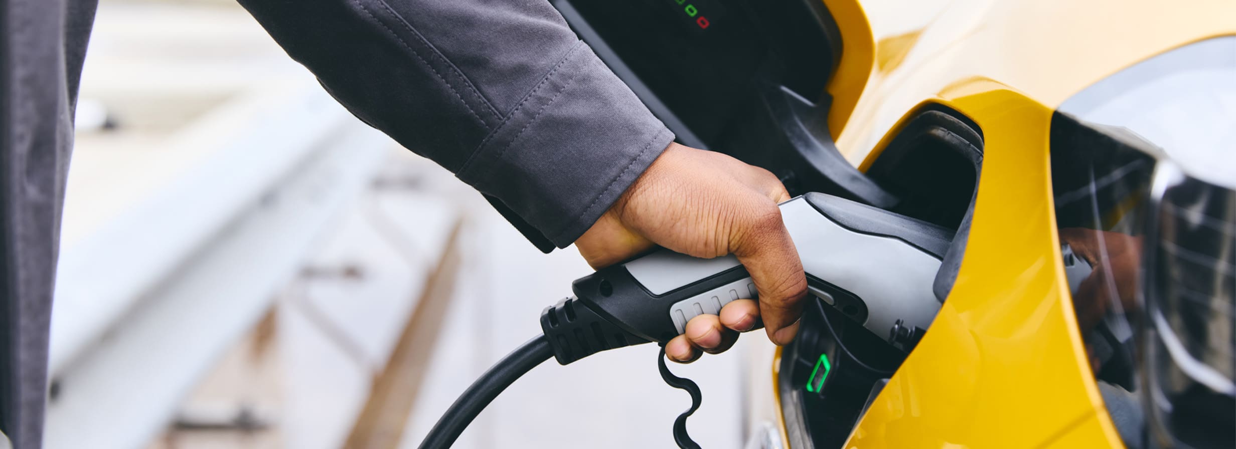 Person plugging electric vehicle into charge