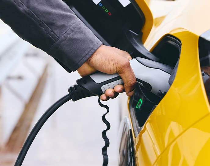 Person plugging electric vehicle into charge
