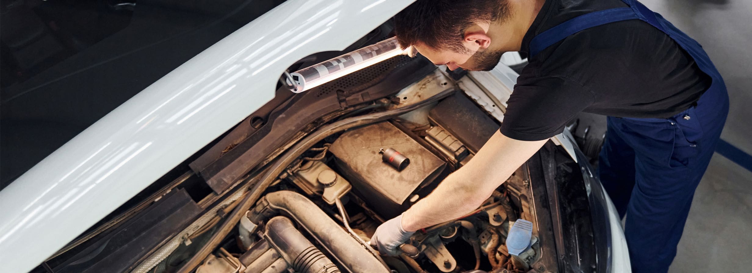Person inspecting a car engine
