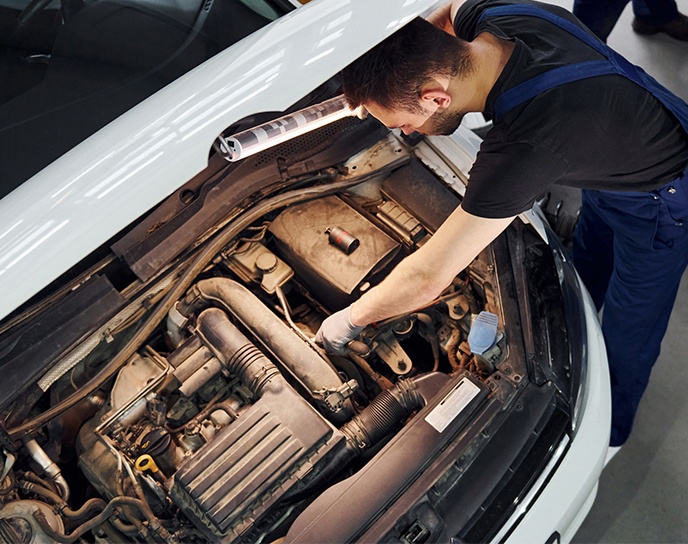 Person inspecting a car engine